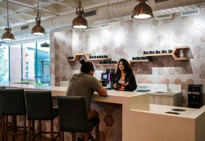 Sleek office café and break area with honeycomb-patterned walls and pendant lighting.