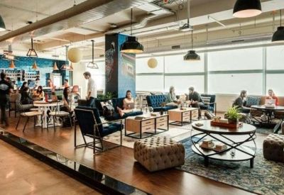 Large lounge and coworking space with diverse seating options and floor-to-ceiling windows.