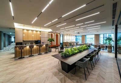 Spacious communal area with a service bar, a long table featuring a planter, and warm overhead lighting.