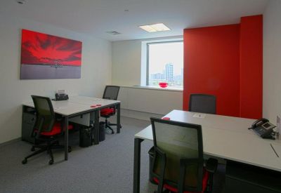Private office suite with two white desks and a vibrant red accent wall.