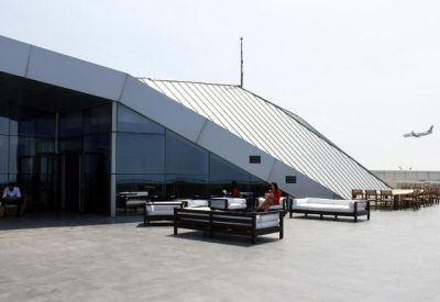 Spacious outdoor communal terrace with lounge seating and an airplane in the distance.