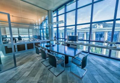Large modern conference room with a blue-tinted glass wall overlooking the city.