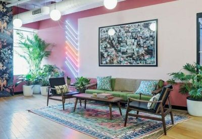 Colorful breakout area with a floral mural, velvet sofa, and eclectic decor.