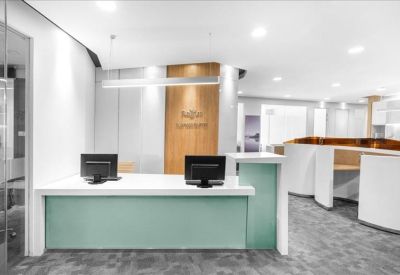 Professional reception area with a mint-green front desk and wooden wall accents.