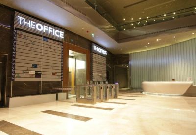 Lobby area featuring secure turnstile access points under a large branded sign.