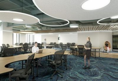 Open-plan office with curved wooden desks and modern circular light fixtures.