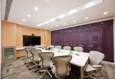 Modern meeting room with a marble table, ergonomic chairs, and a purple feature wall.