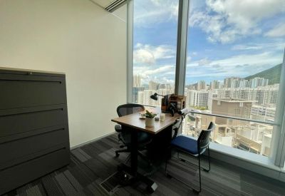 Private two-person office suite with a wooden desk situated next to a large window overlooking the city.
