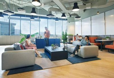 Lounge area with light grey sofas, coffee table, and large windows.