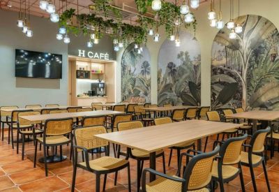 Vibrant on-site cafe with botanical wall murals and warm hanging lights.