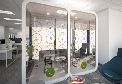 Private glass-enclosed call booths with decorative privacy film and stools.