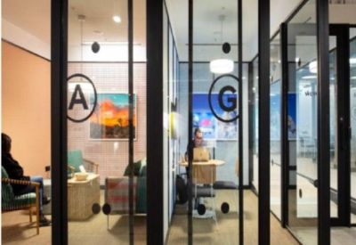 Private glass-fronted office pods with warm interior lighting and abstract wall art.