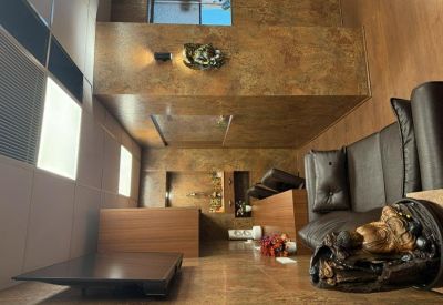 Compact lounge area with a dark leather sofa and wooden wall paneling.
