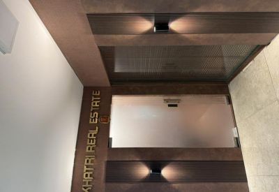 Branded signage wall for Khatri Real Estate with modern downlighting.