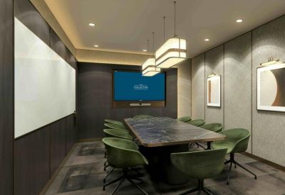 Sophisticated boardroom with a dark marble table, green velvet chairs, and a large wall-mounted screen.