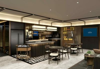 Sleek coffee bar and refreshments area with cafe-style seating and decorative tile flooring.