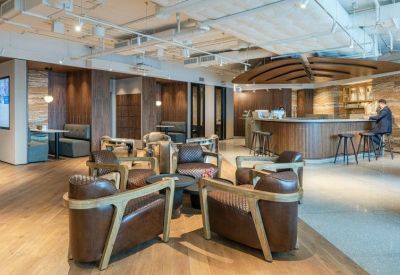 Warm breakout space with leather armchairs and a modern cafe bar.