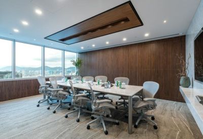 Modern boardroom with a white table and large windows overlooking the harbor.