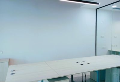 Open-plan desk with integrated cable management and overhead strip lighting.