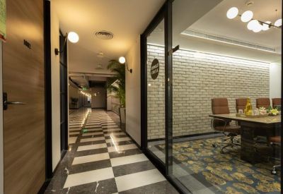 Modern hallway with checkered marble floors and glass-walled meeting room.