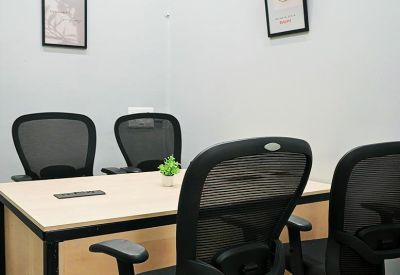 Meeting table with four mesh chairs and framed wall art.