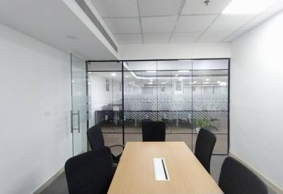 Small conference room with a wooden table and frosted glass partitions.