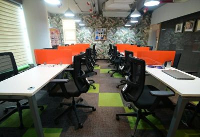 Spacious workspace featuring orange desk dividers and a leaf-patterned accent wall.