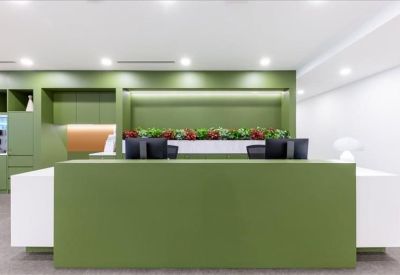 Modern green reception desk with built-in planter and white accents.