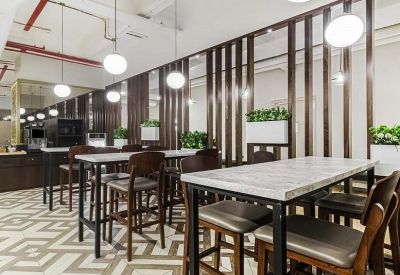 Bright dining area with high-top marble tables, wooden bar stools, and decorative wall partitions.