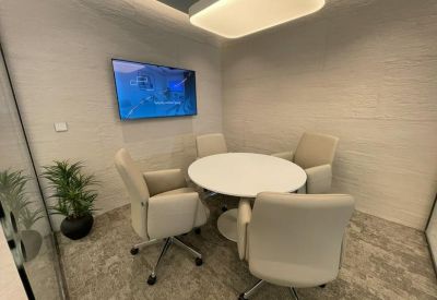 Private glass-walled office suite with a desk and ergonomic chair.