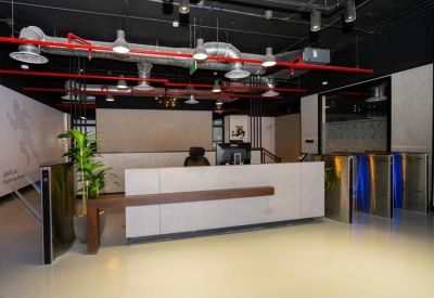 Bright reception area featuring a white front desk with wood accents and overhead industrial lighting.