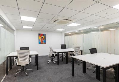 Bright four-person private office with white desks and colorful wall art.