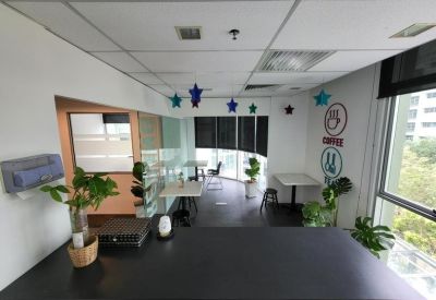 Breakout area with white tables, potted plants, and wall decals.
