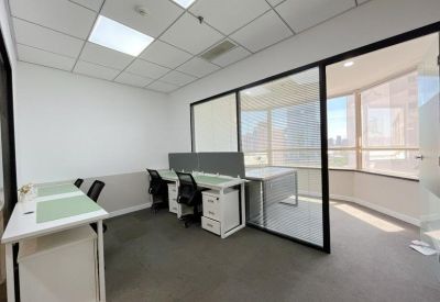 Bright private office suite with two white desks and large window views.