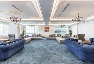 Luxe lounge area featuring blue tufted sofas and elegant chandeliers.