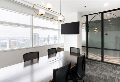 Modern meeting room featuring a dark wood table and city views through large windows.