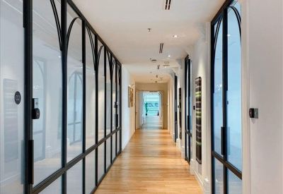 Bright hallway with arched glass doors and light wood flooring.