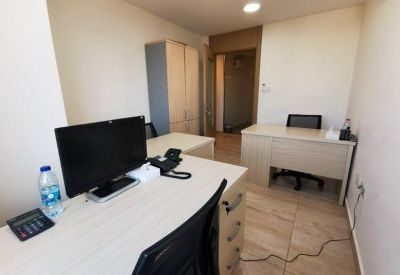 Internal office space featuring two wooden desks and black ergonomic chairs.