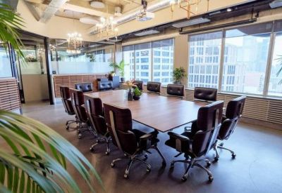 Professional boardroom with a large timber table, leather chairs, and expansive window views.
