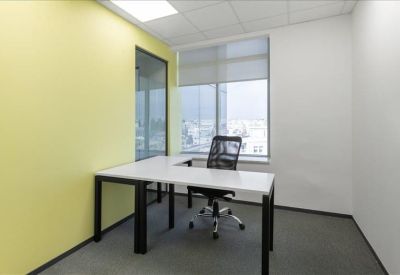 Private office suite with an L-shaped desk and yellow feature wall.