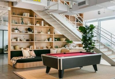 Recreation area with a pool table, wooden shelving, and a modern staircase.