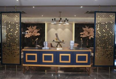 Elegant reception area with a navy and gold desk and decorative screens.