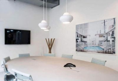 Bright conference room with a large oval table and white pendant lighting.
