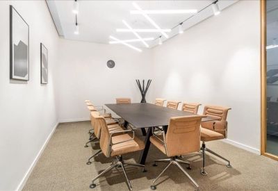 Spacious meeting room featuring tan leather chairs and creative criss-cross ceiling lights.