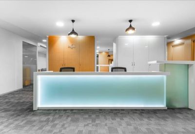 Bright reception area with a glowing blue desk and wood paneling.