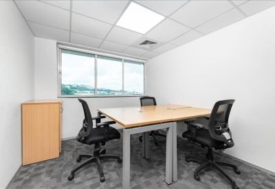 Small three-person private office with a window and light wood desks.