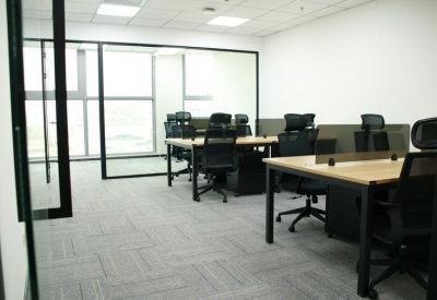 Modern open-plan office with multiple workstations and glass partitions.