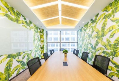 Bright conference room featuring a wooden table and vibrant banana leaf wallpaper.