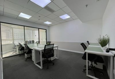 Bright four-person private office with white desks and black mesh chairs.