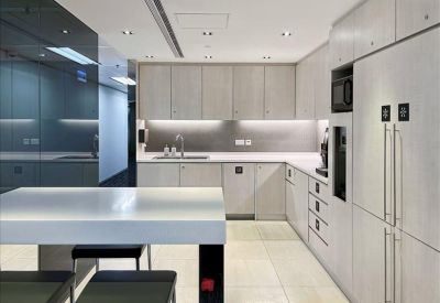 Modern white kitchen and pantry area with integrated appliances and breakfast bar.